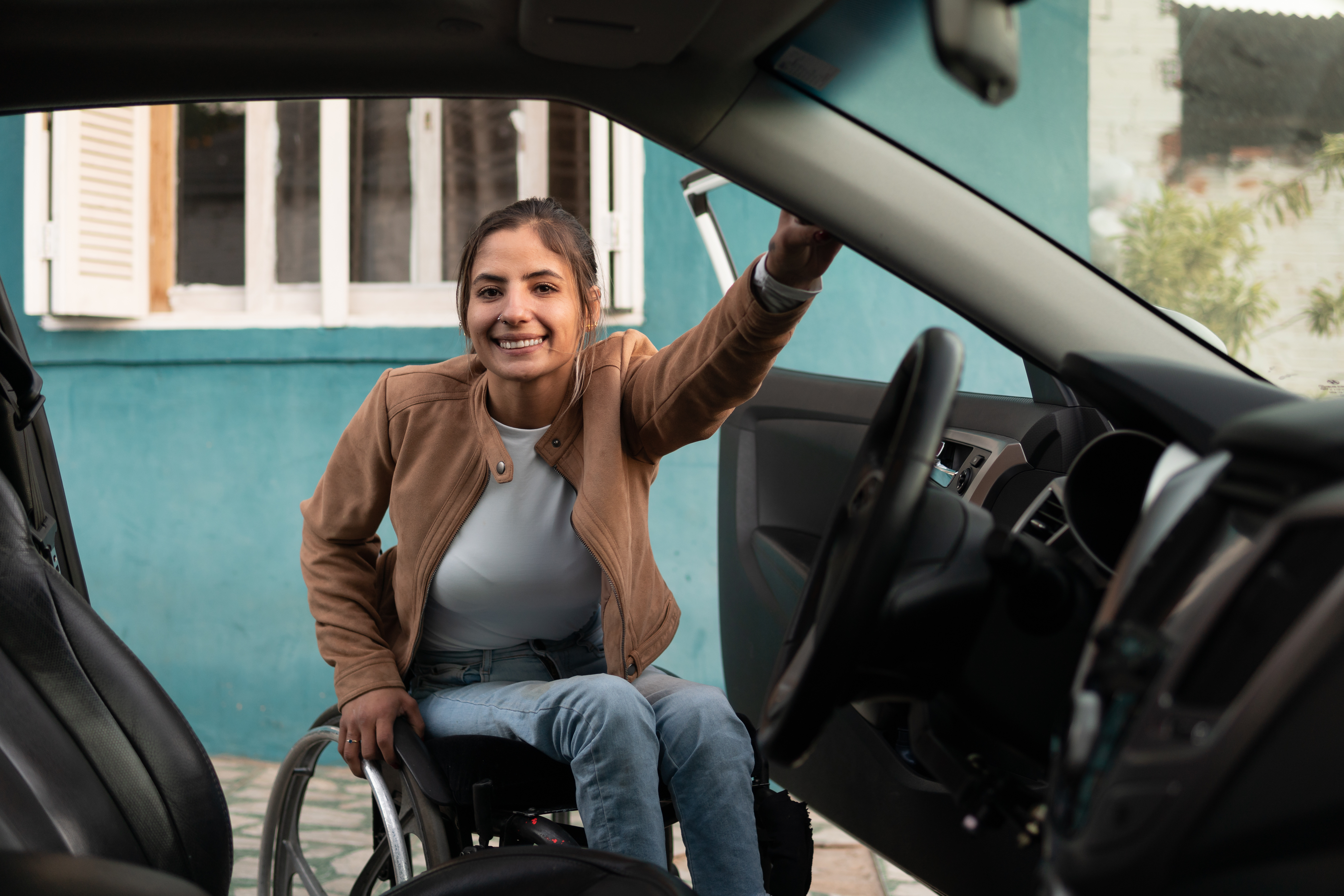 Woman getting into a car from her wheelchair